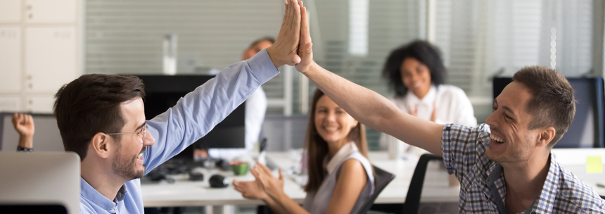 team mates high fiving in office setting